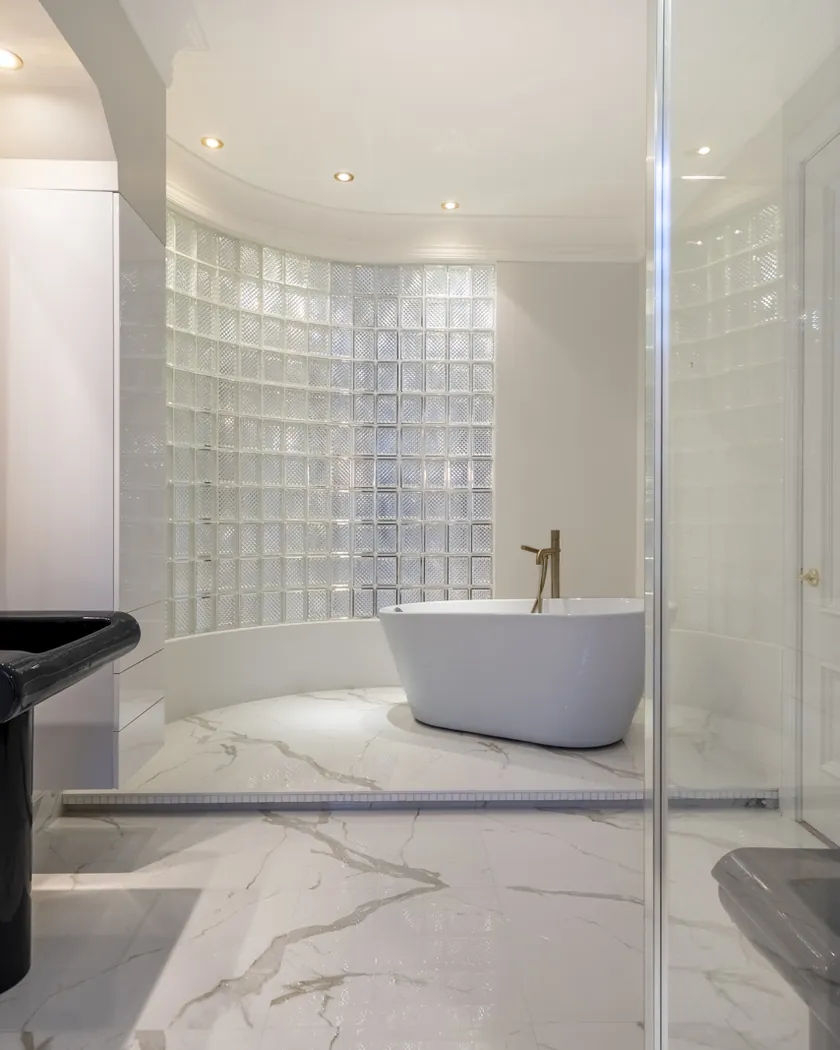 Salle de bain en marbre avec baignoire autoportante et douche vitrée